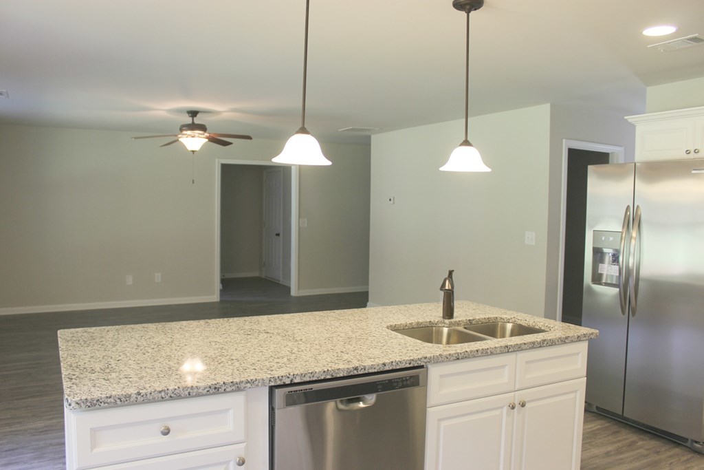 965 Weldon Road Forsyth, GA 31029 - Photo 5 of 11 a kitchen with stainless steel appliances granite countertop a sink a refrigerator and chandelier