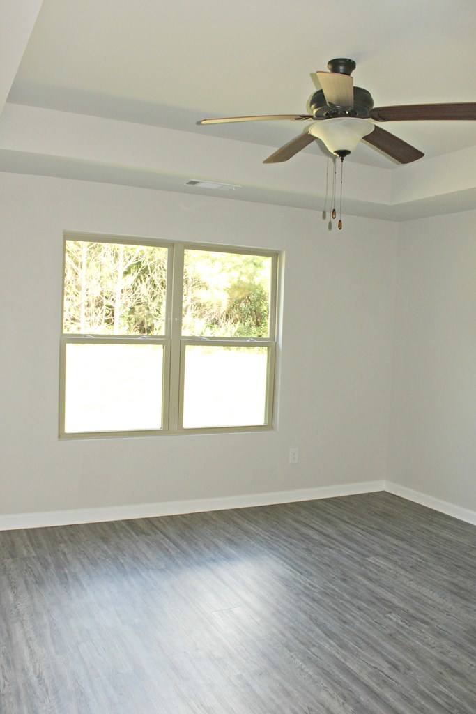 965 Weldon Road Forsyth, GA 31029 - Photo 7 of 11 an empty room with wooden floor fan and windows