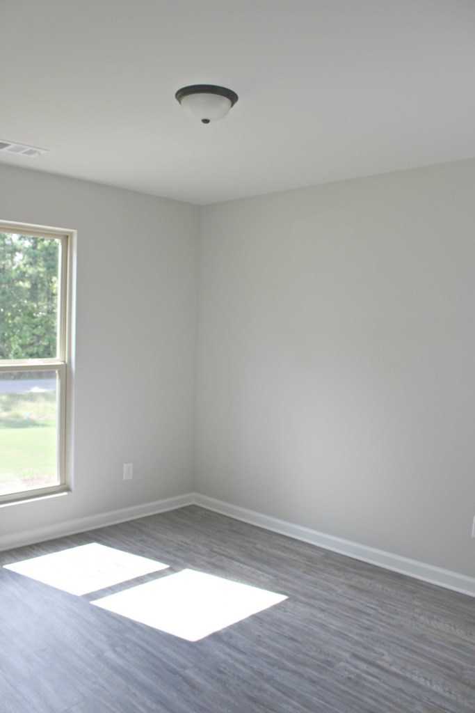 965 Weldon Road Forsyth, GA 31029 - Photo 10 of 11 wooden floor in an empty room with a window
