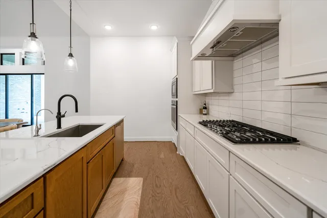 a kitchen with stainless steel appliances a sink stove and cabinets