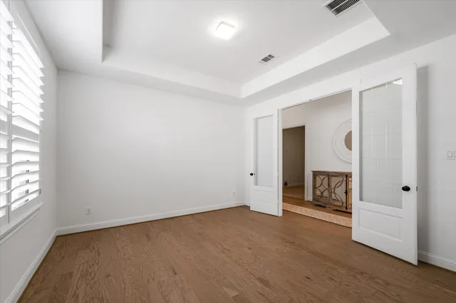 an empty room with a fireplace and windows