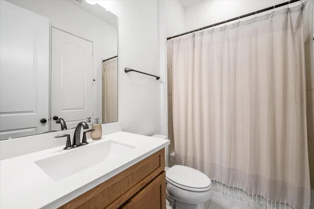a bathroom with a sink a toilet and shower curtain