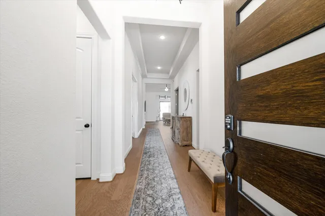 a view of a hallway with wooden floor and staircase