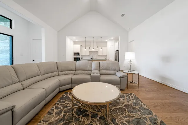 a living room with furniture a chandelier and a dining table