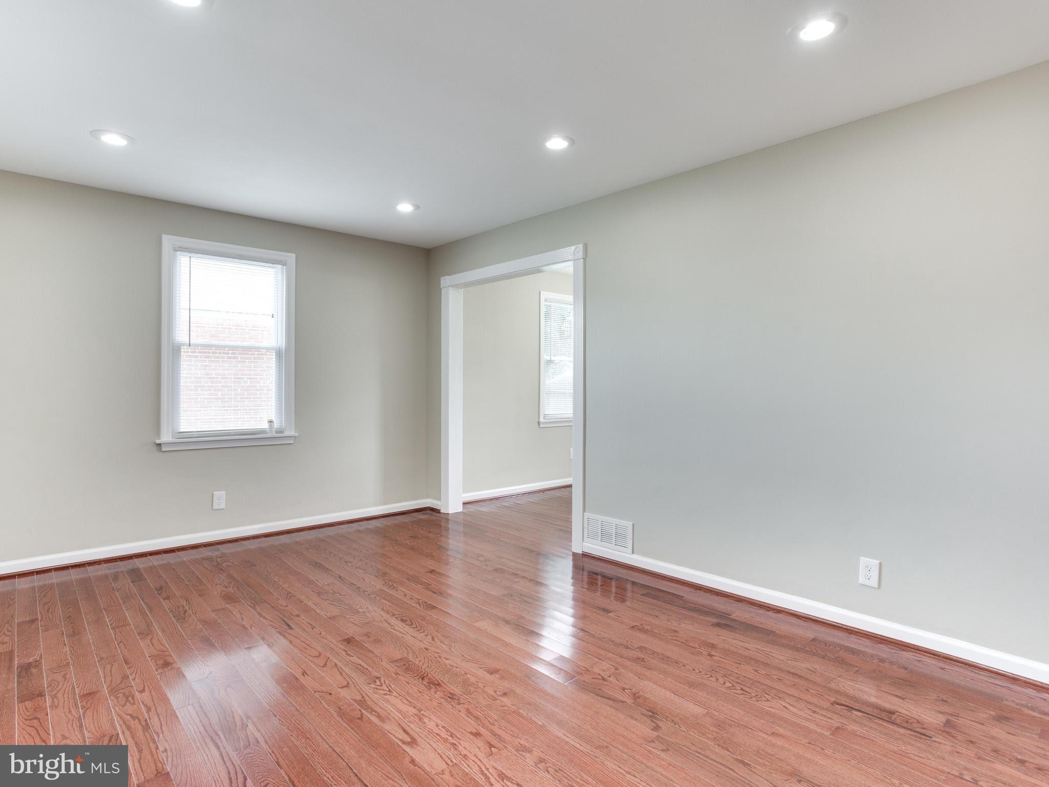 3529 Wild Cherry Road Baltimore, MD 21244 - Photo 17 of 30 a view of an empty room with wooden floor and a window