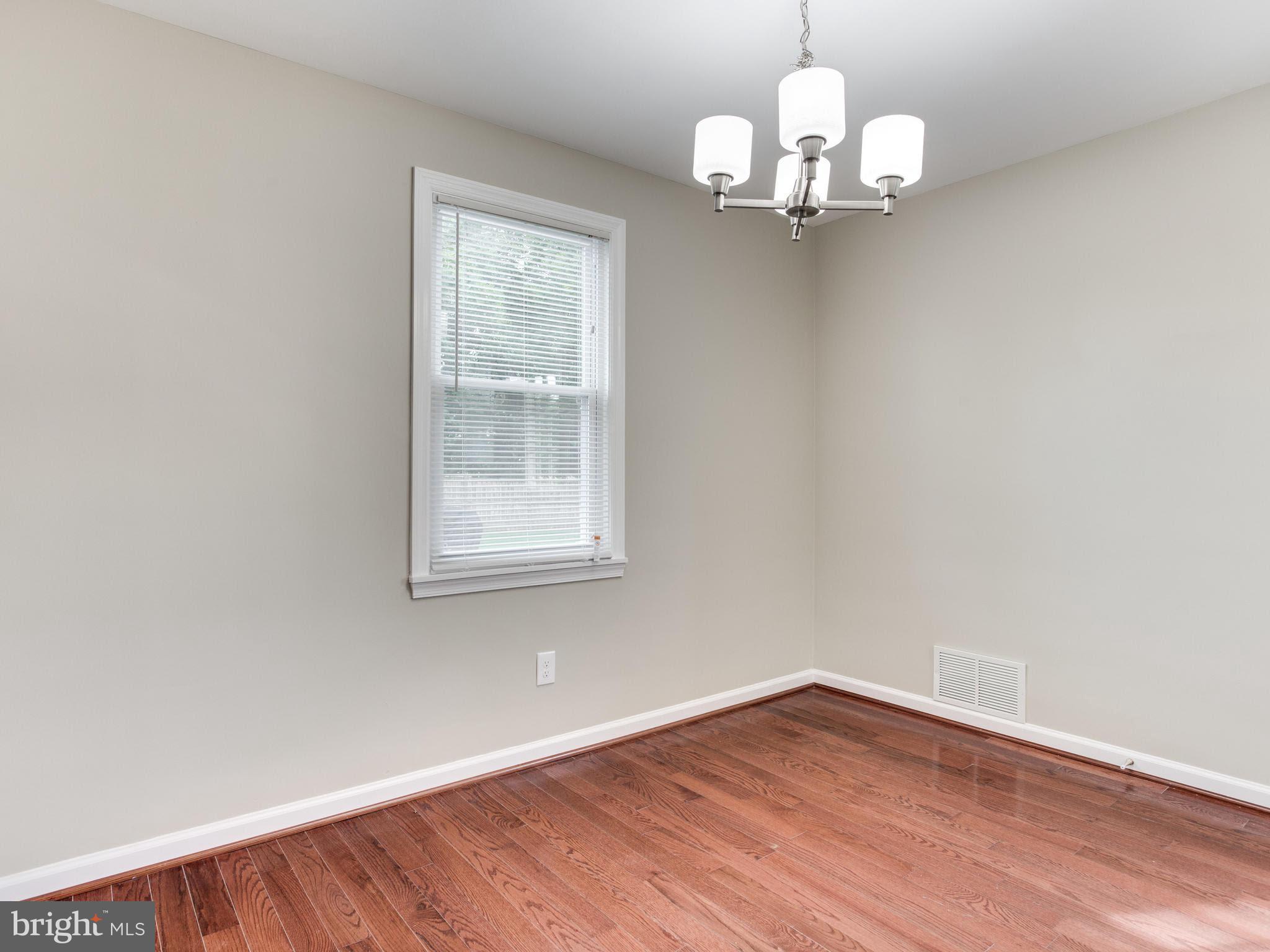 3529 Wild Cherry Road Baltimore, MD 21244 - Photo 5 of 30 an empty room with wooden floor and windows