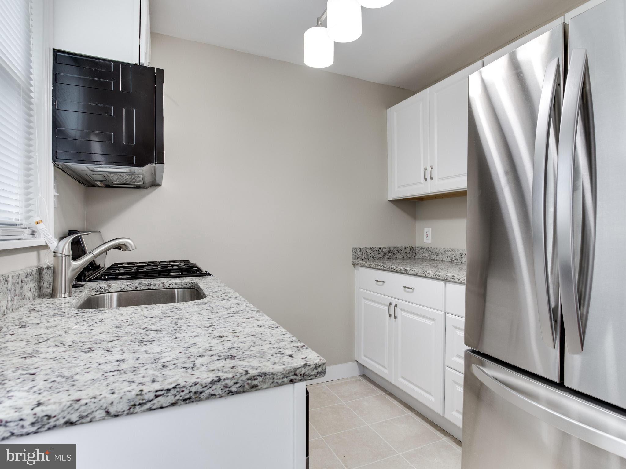3529 Wild Cherry Road Baltimore, MD 21244 - Photo 7 of 30 a kitchen with stainless steel appliances granite countertop a sink stove and refrigerator
