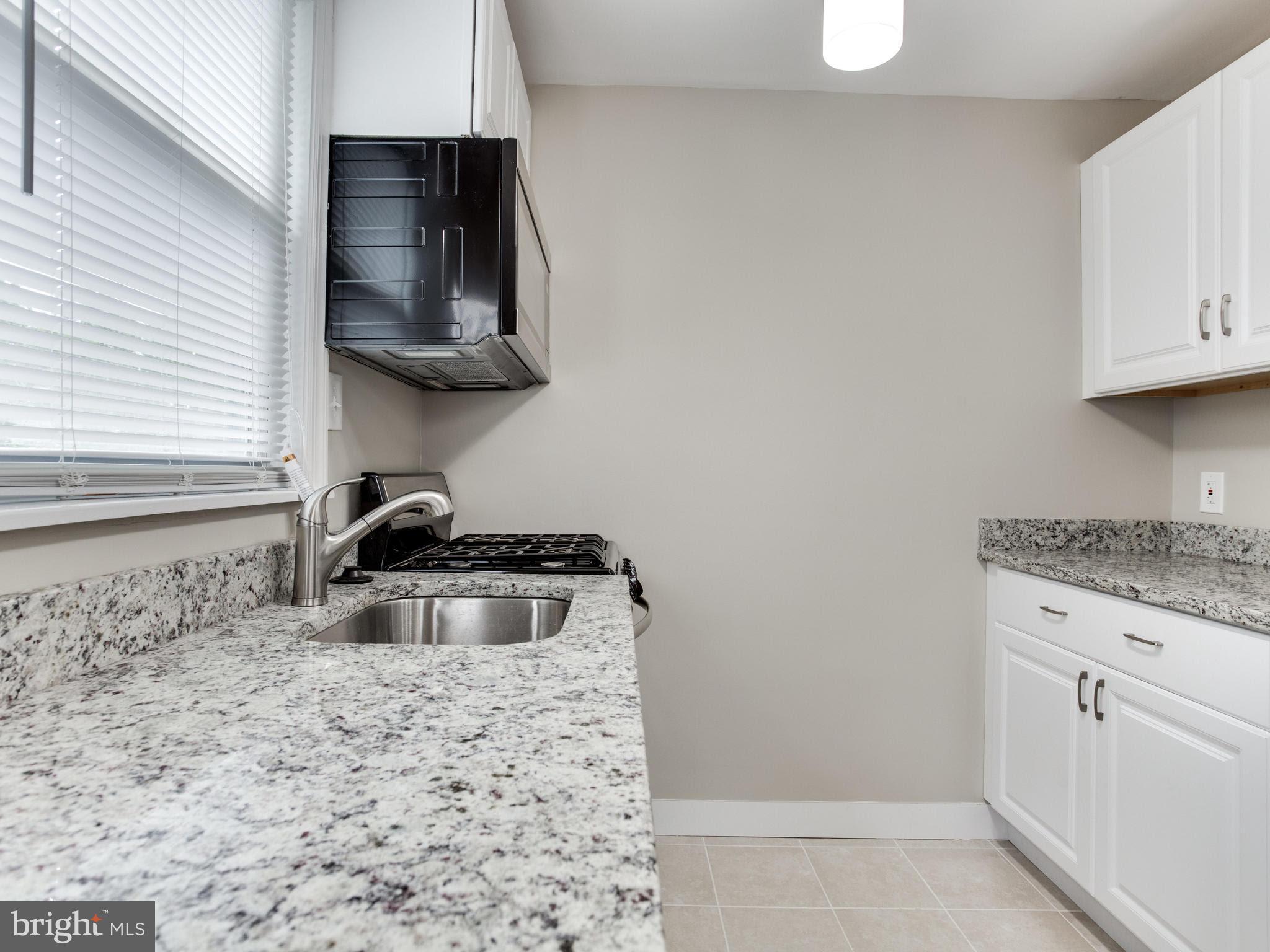 3529 Wild Cherry Road Baltimore, MD 21244 - Photo 8 of 30 a kitchen with granite countertop a stove and a sink