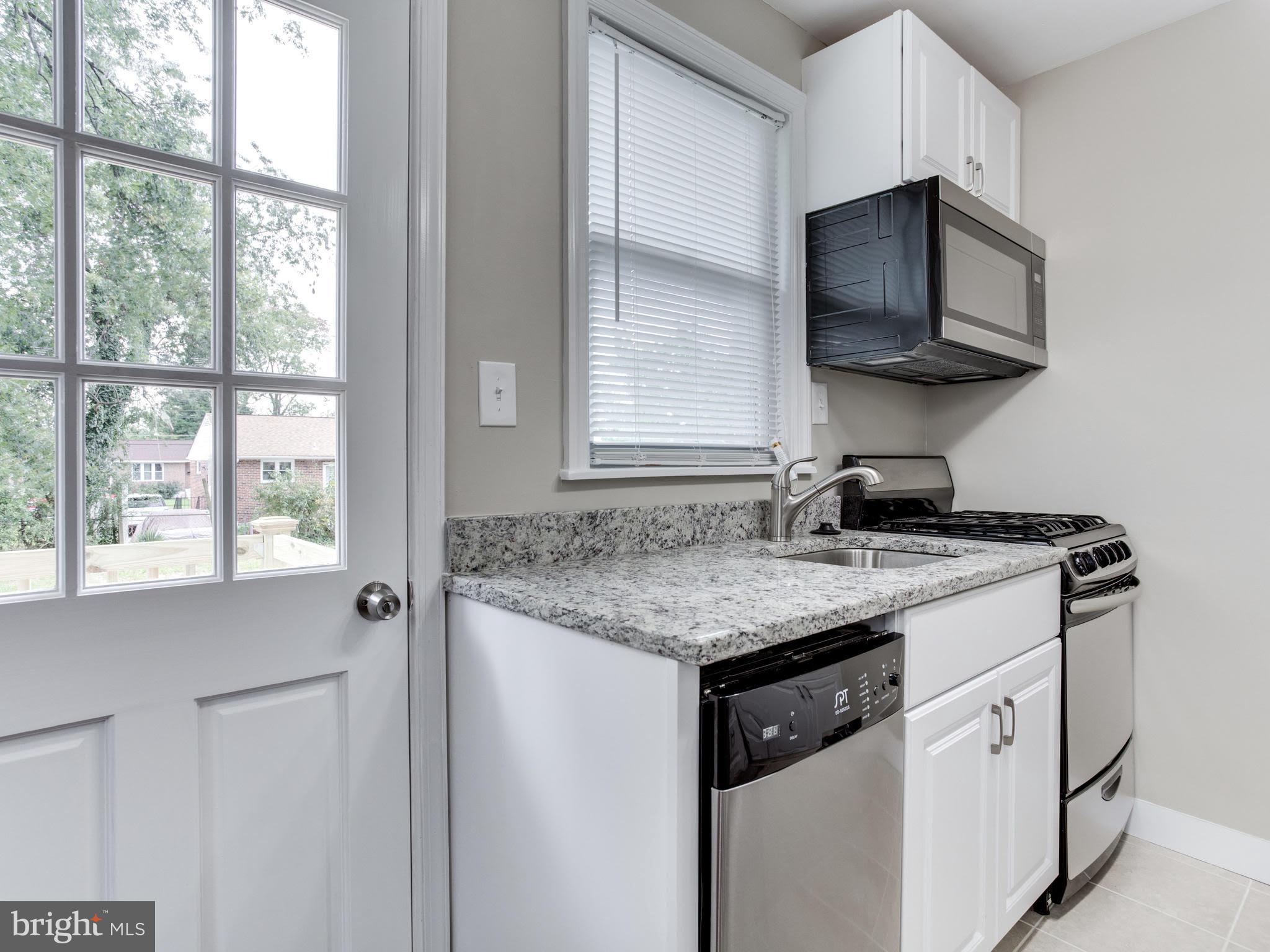 3529 Wild Cherry Road Baltimore, MD 21244 - Photo 9 of 30 a kitchen with stainless steel appliances granite countertop a sink and a microwave