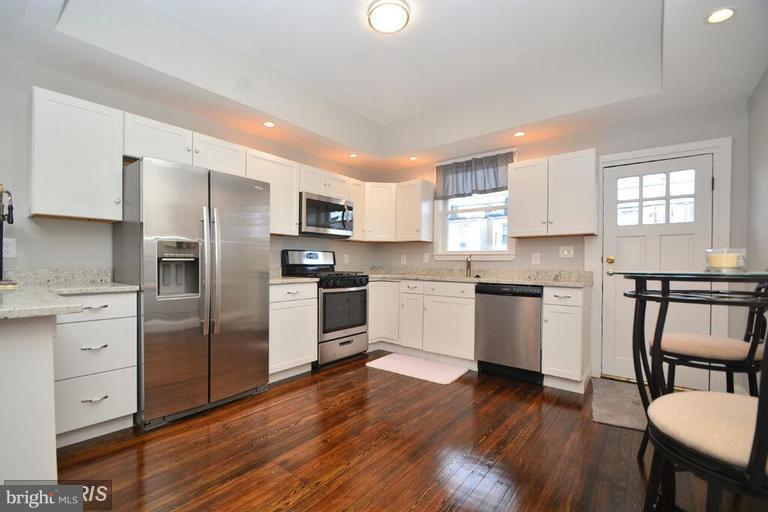 3529 Wild Cherry Road Baltimore, MD 21244 - Photo 10 of 30 a kitchen with white cabinets and stainless steel appliances