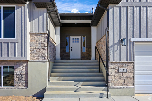 1139 South 4475 West West Point, UT 84015 - Photo 4 of 33 Doorway to property featuring stone siding, board and batten siding, and a garage