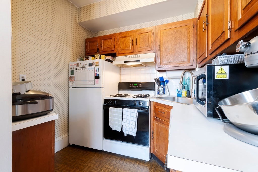 1161 Commonwealth Avenue, Unit 2 Boston, MA 02134 - Photo 6 of 17 a kitchen with stainless steel appliances granite countertop a refrigerator a stove top oven a sink and dishwasher