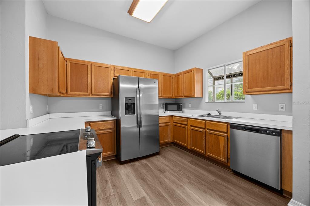 5291 Southwest 97 Way Gainesville, FL 32608 - Photo 13 of 24 a kitchen with stainless steel appliances granite countertop a refrigerator a stove top oven a sink and dishwasher
