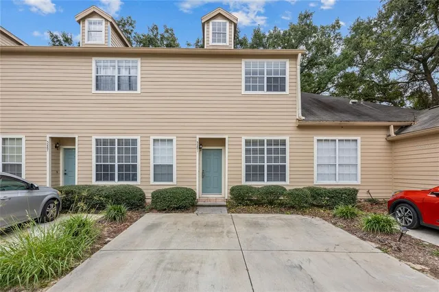 a view of a house with a small yard plants and large tree