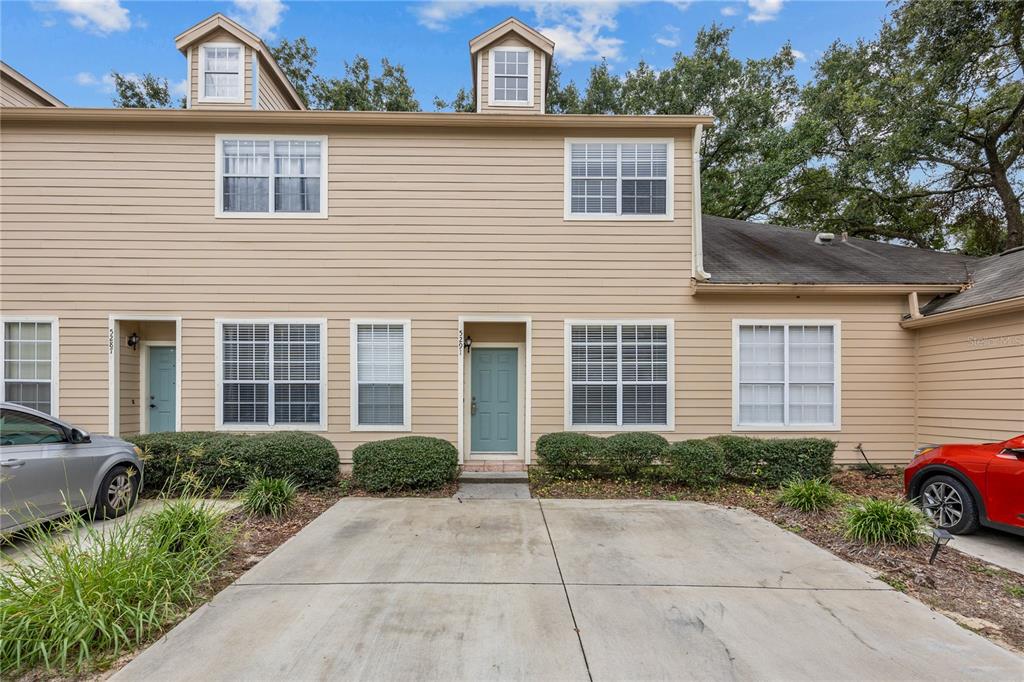 5291 Southwest 97 Way Gainesville, FL 32608 - Photo 4 of 24 a view of a house with a small yard plants and large tree