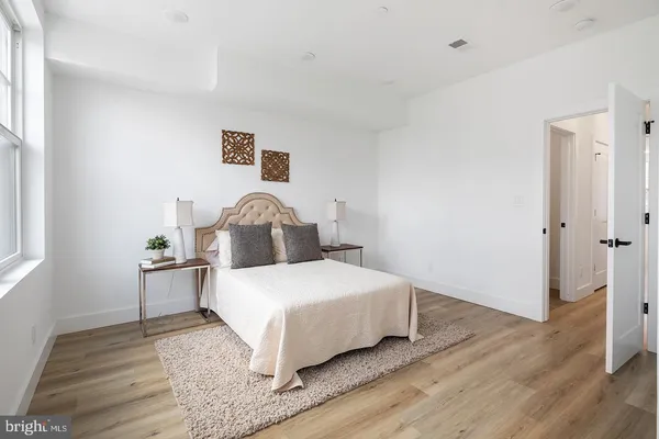 a bedroom with a bed and wooden floor