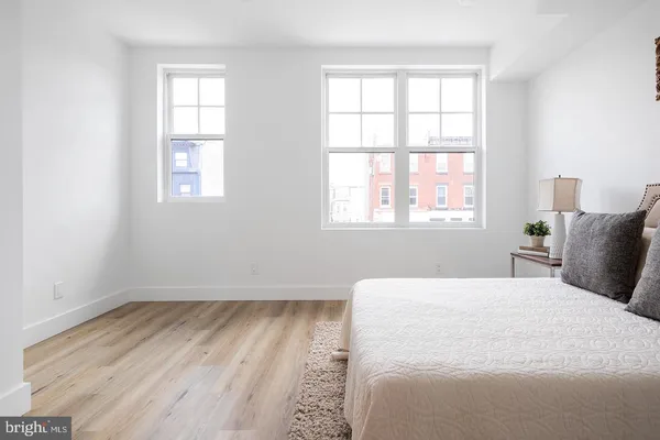a bedroom with a bed and wooden floor