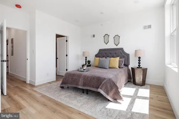 a bedroom with a bed and wooden floor