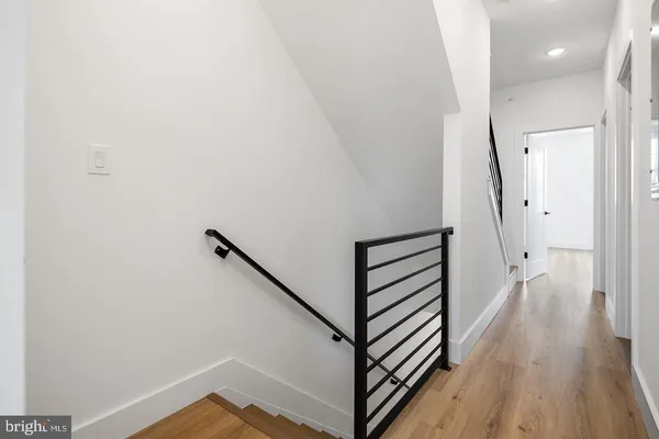 a view of a hallway with wooden floor and staircase