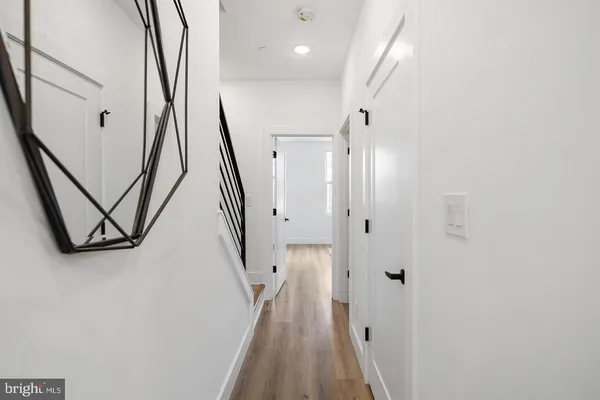 a view of a hallway with wooden floor and staircase