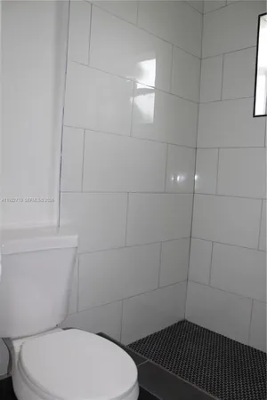 a bathroom with a toilet and a shower