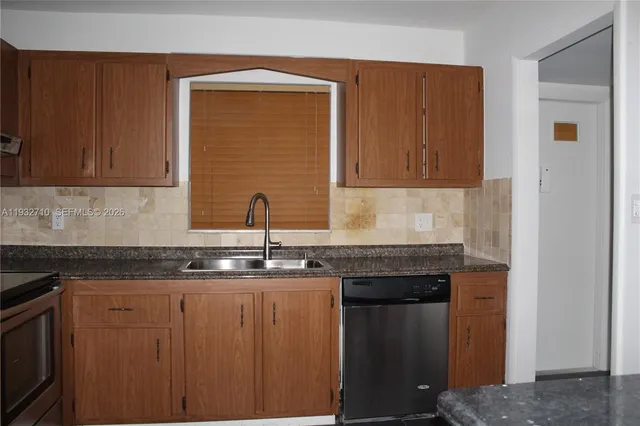 a kitchen with granite countertop a sink and cabinets
