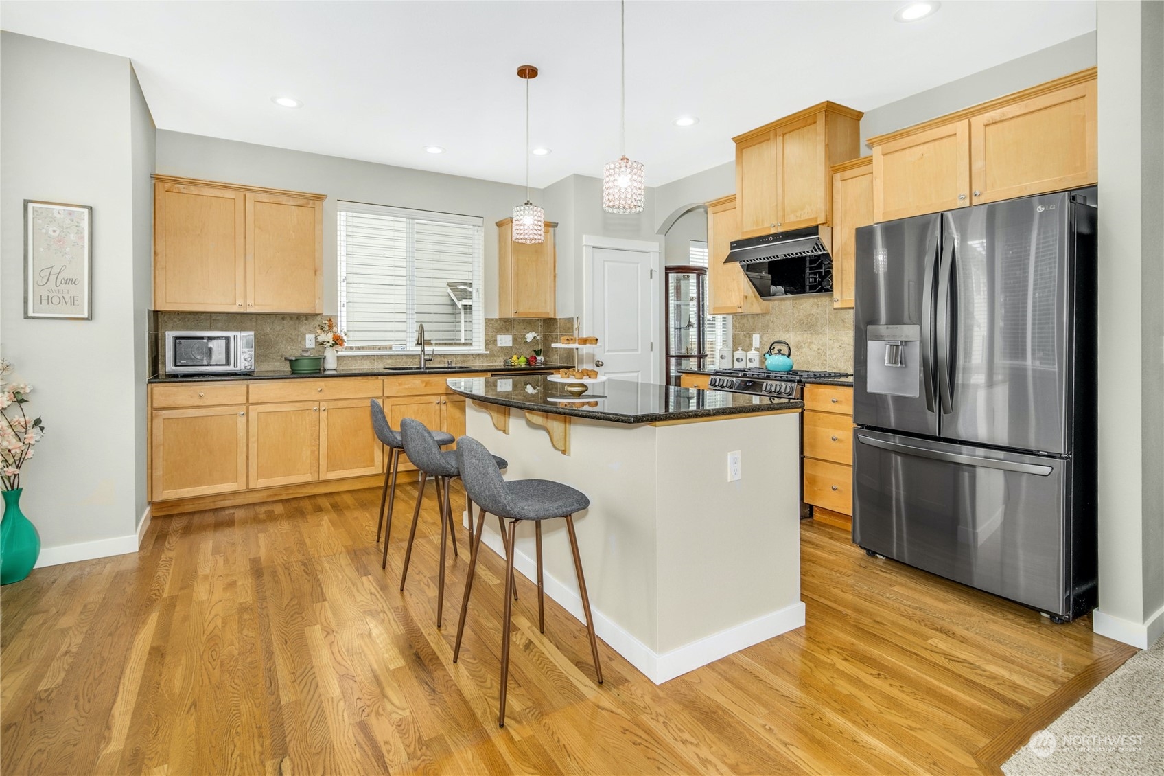 3604 222nd Place Southeast Bothell, WA 98021 - Photo 12 of 38 a kitchen with stainless steel appliances a refrigerator a stove a sink dishwasher and white cabinets with wooden floor