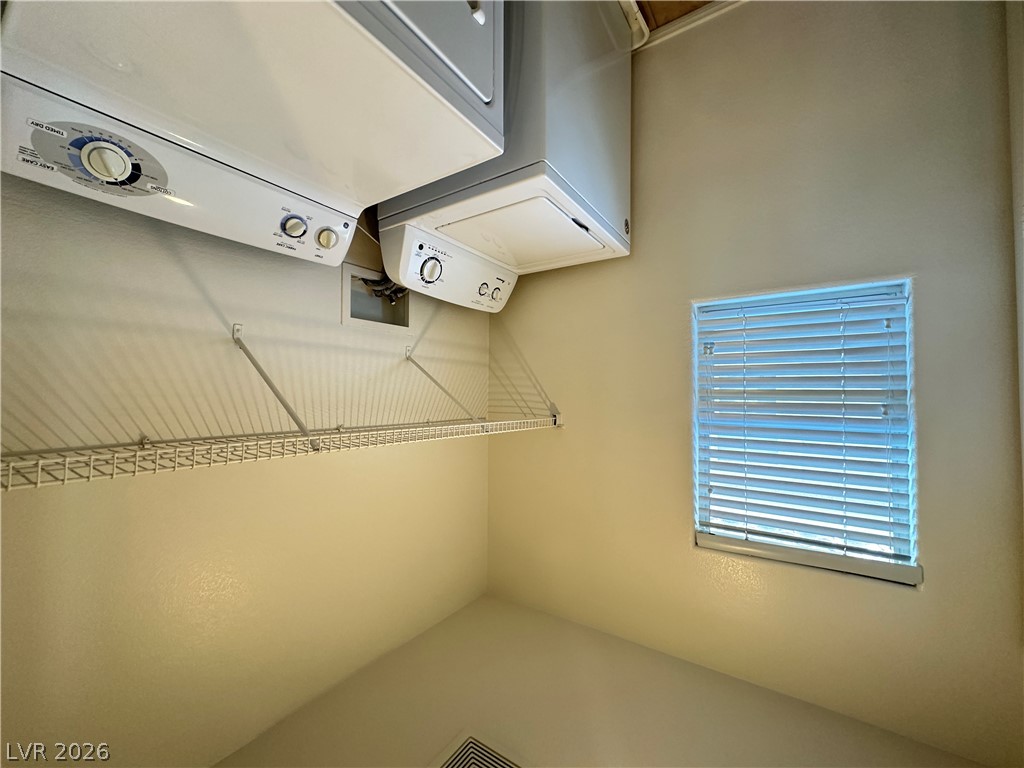 7305 Prussian Green Street Las Vegas, NV 89139 - Photo 17 of 23 Functional laundry room offers convenient stacked appliances and ample shelving for organized storage.