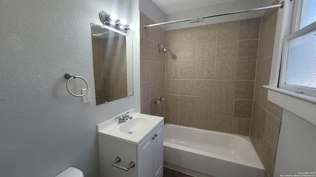 a bathroom with a shower a sink and a mirror