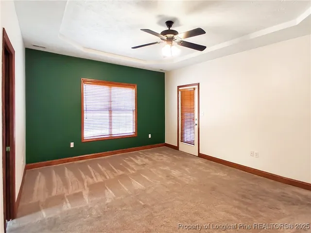 an empty room with windows and fan