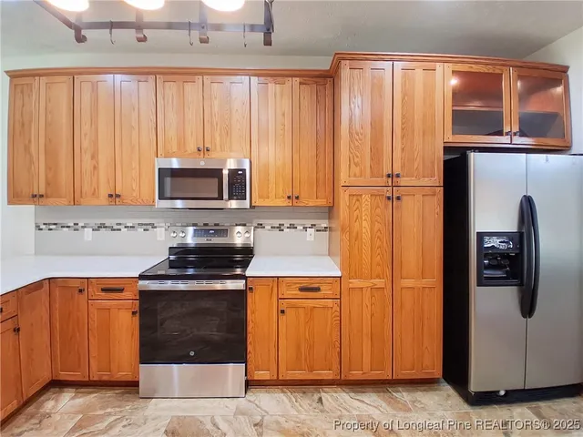 a kitchen with stainless steel appliances granite countertop a refrigerator a stove a sink and dishwasher