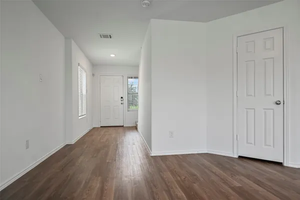 a view of a room with wooden floor and white doors
