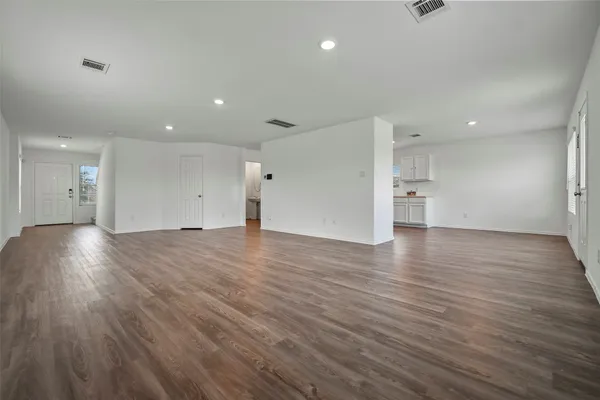 a view of empty room with wooden floor