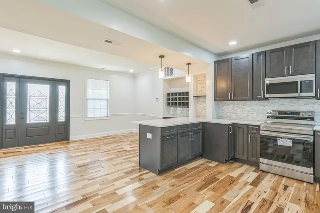 a kitchen with stainless steel appliances granite countertop a stove a sink and a microwave