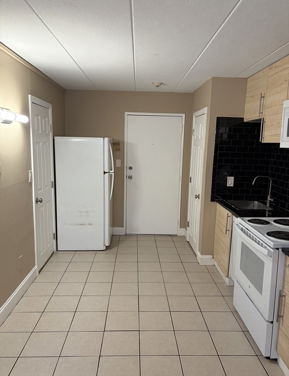 126 Beaver Street, Unit 65 Framingham, MA 01702 - Photo 4 of 15 a kitchen with a sink a refrigerator and cabinets