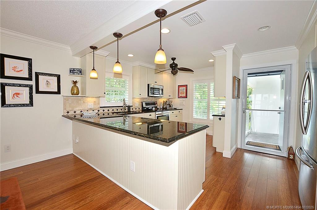 1860 Southwest Palm City Road, Unit 206 Stuart, FL 34994 - Photo 20 of 39 a kitchen with stainless steel appliances granite countertop a sink dishwasher a refrigerator and wooden floor
