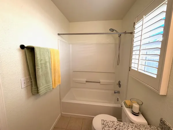 a bathroom with a shower a bath tub and a window