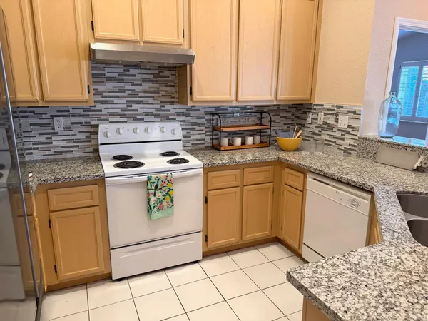 a kitchen with stainless steel appliances granite countertop a stove a sink and a microwave