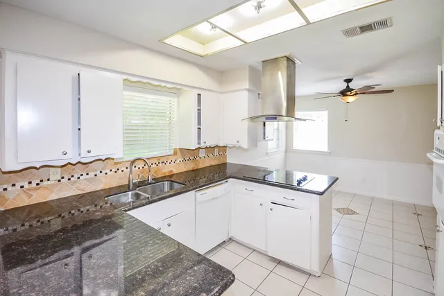 a kitchen with granite countertop a sink and cabinets