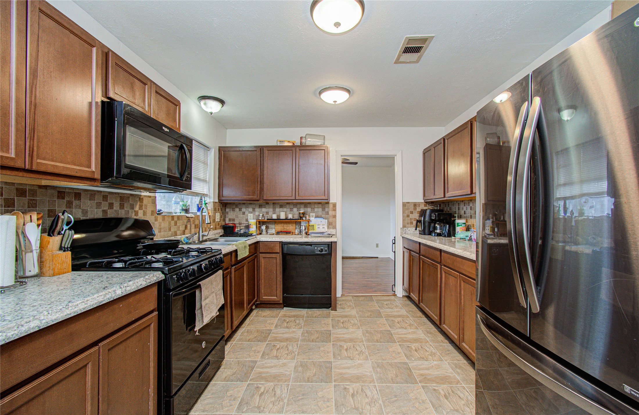 1710 West 11th Street Freeport, TX 77541 - Photo 15 of 34 a kitchen with stainless steel appliances granite countertop a stove top oven a sink dishwasher a refrigerator and cabinets with wooden floor