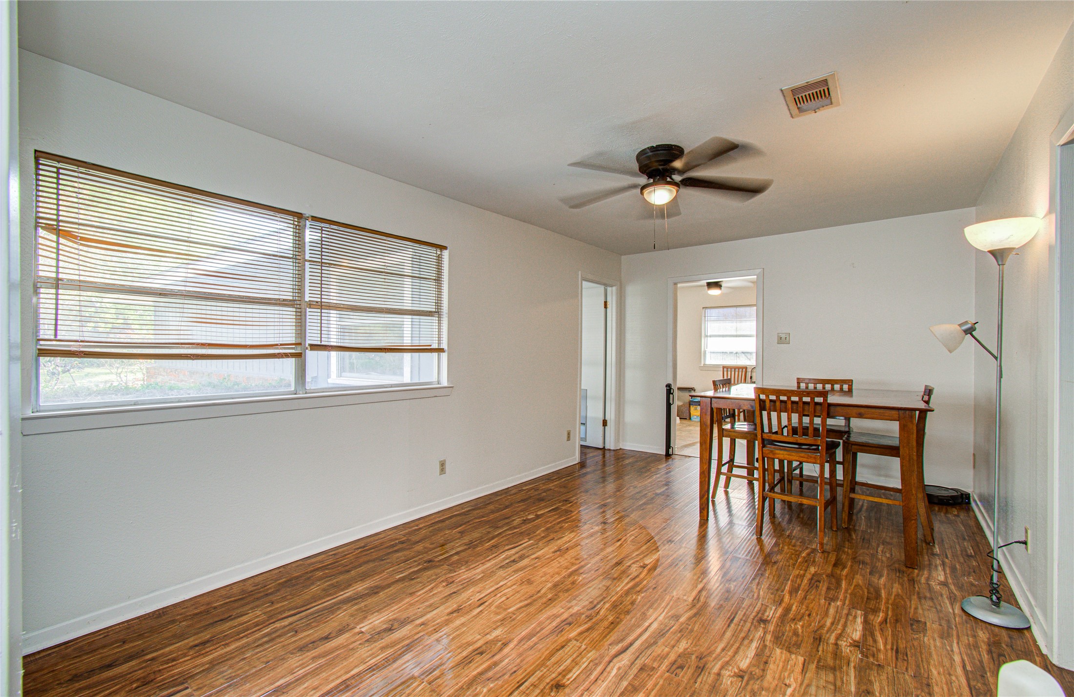 1710 West 11th Street Freeport, TX 77541 - Photo 7 of 34 a dining room with wooden floor a chandelier a glass table and chairs