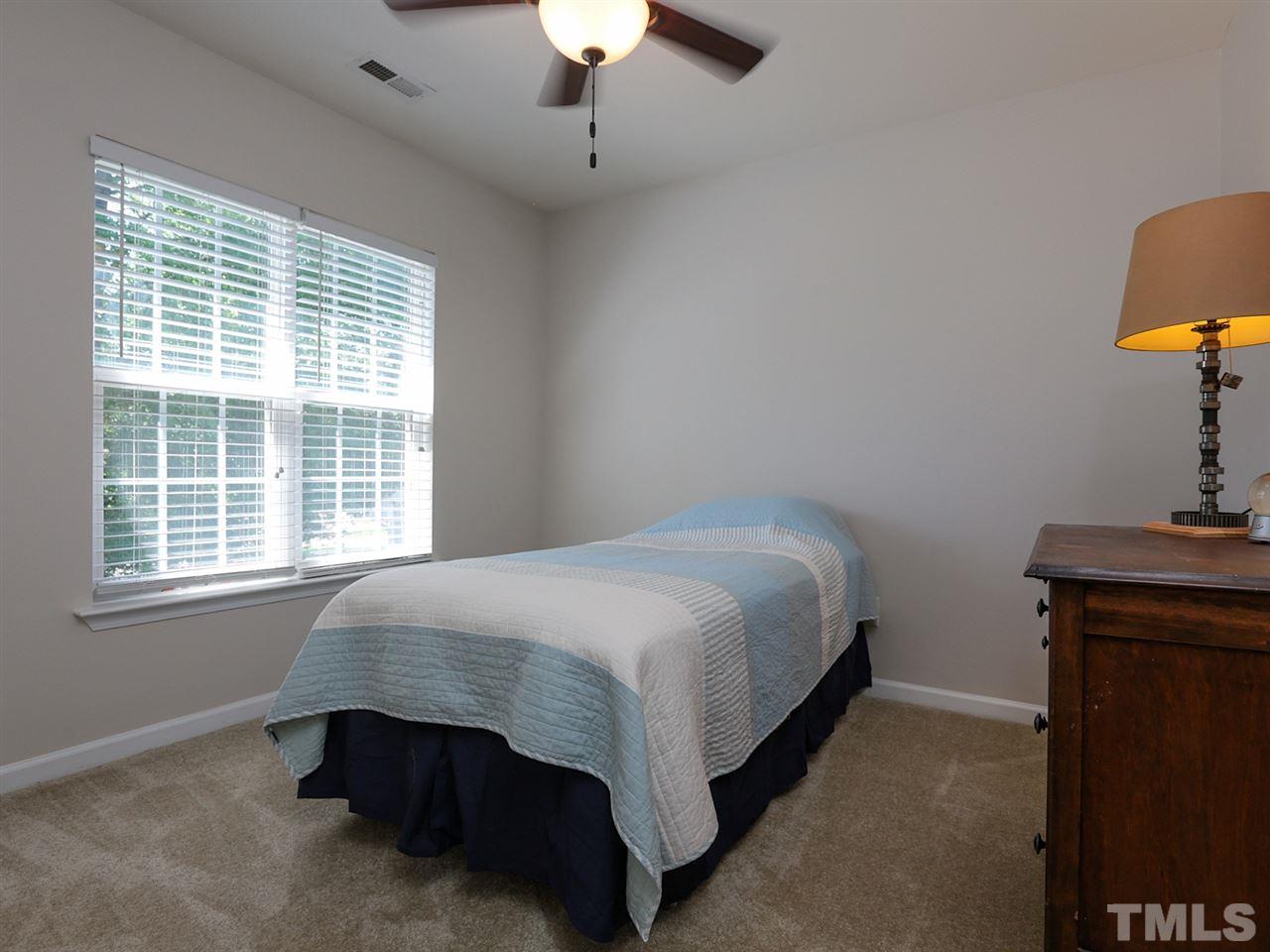 8204 Shadow Stone Court Raleigh, NC 27613 - Photo 16 of 21 a bed sitting in a bedroom next to a window