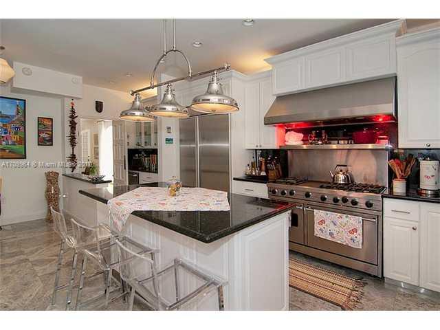 5100 La Gorce Drive Miami Beach, FL 33140 - Photo 6 of 25 a kitchen with kitchen island granite countertop a sink cabinets and stainless steel appliances