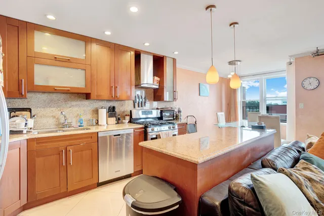 a large kitchen with stainless steel appliances wooden cabinets and a granite counter tops
