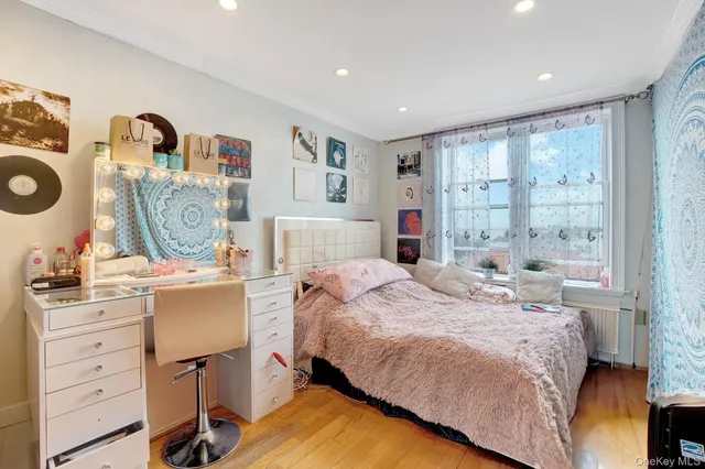 a bedroom with a bed a dresser and next to a window
