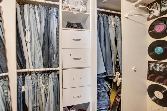 a view of walk in closet with clothes and shoes