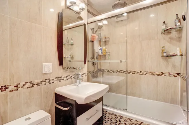 a bathroom with a sink shower and a mirror