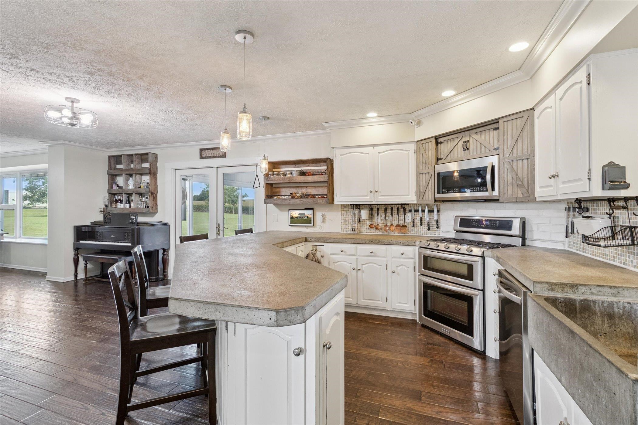 8548 East Edwardsville Road German Valley, IL 61039 - Photo 60 of 70 a kitchen with stainless steel appliances granite countertop a stove top oven a sink dishwasher a dining table and chairs with wooden floor