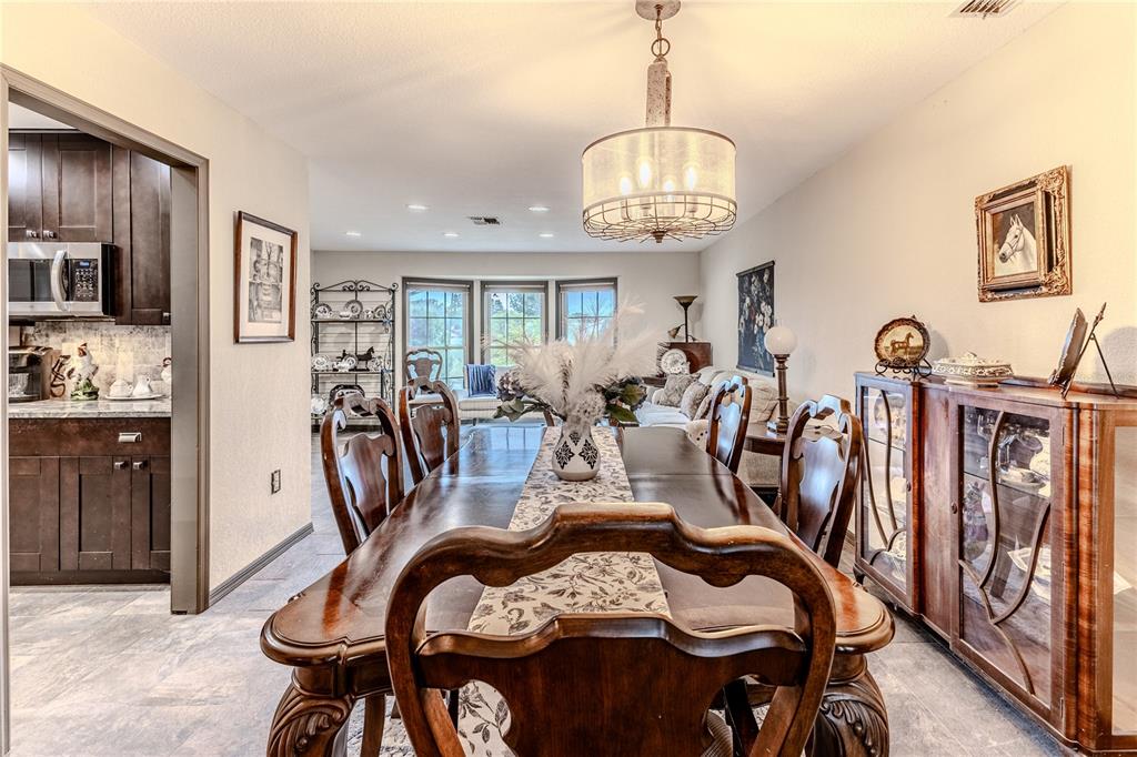 8480 Colma Street Spring Hill, FL 34606 - Photo 17 of 70 a view of a dining room with furniture a chandelier and wooden floor