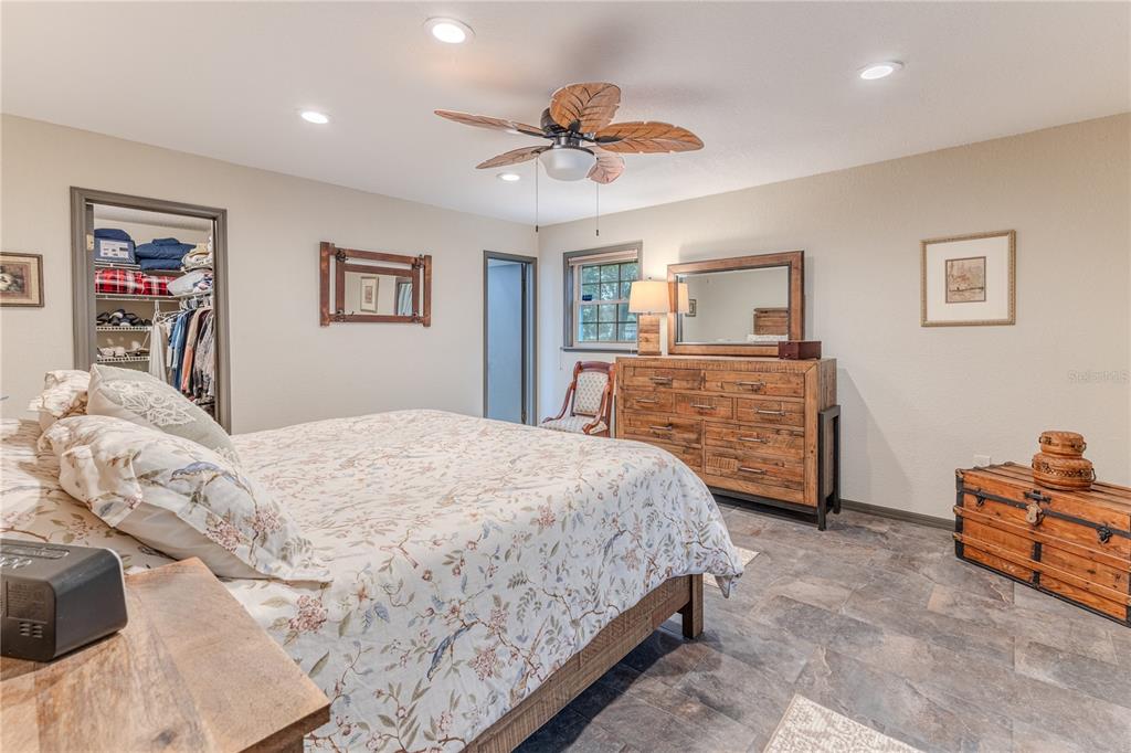 8480 Colma Street Spring Hill, FL 34606 - Photo 33 of 70 a spacious bedroom with a bed and a chandelier